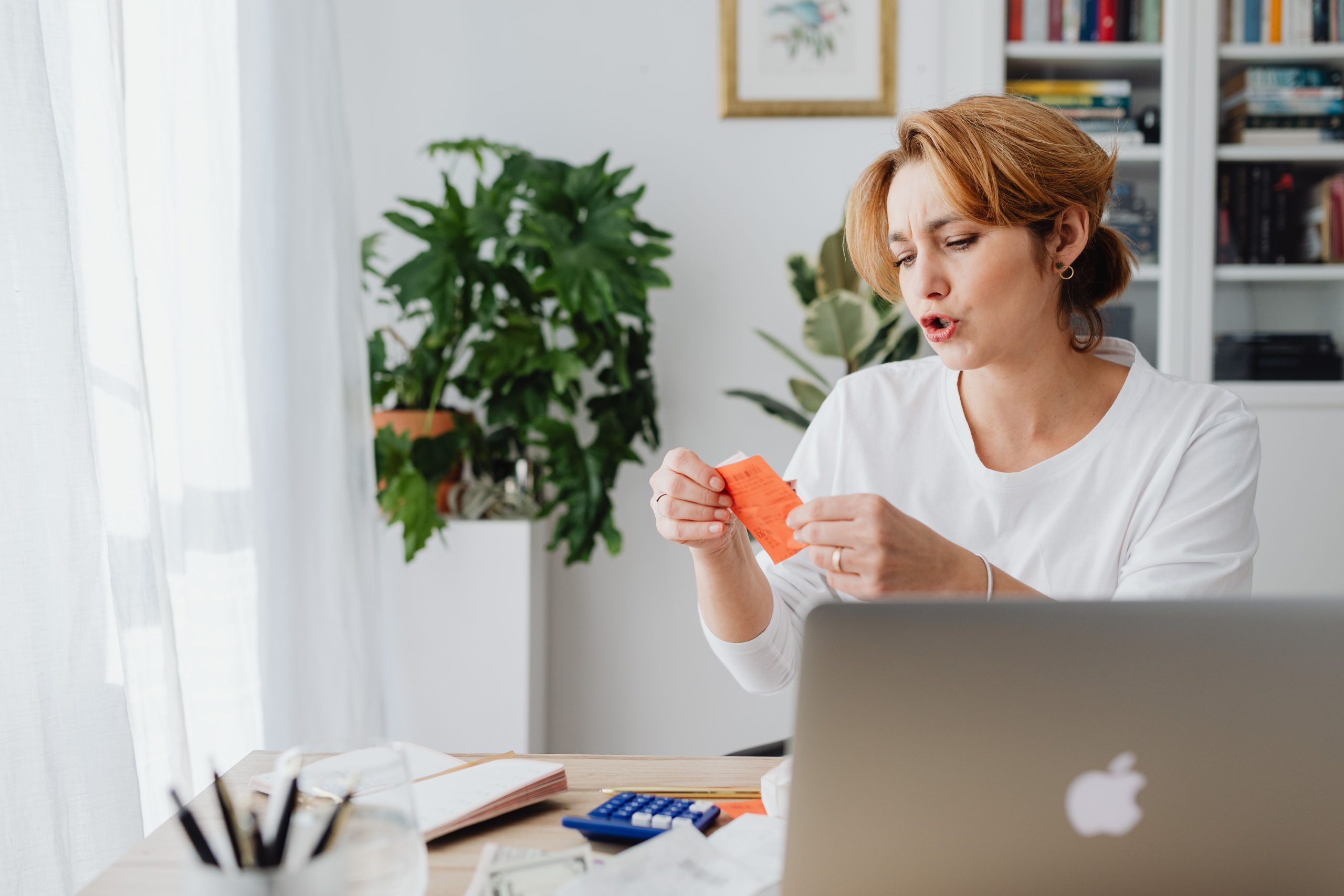 Femme consultant factures a son bureau avec ordinateur