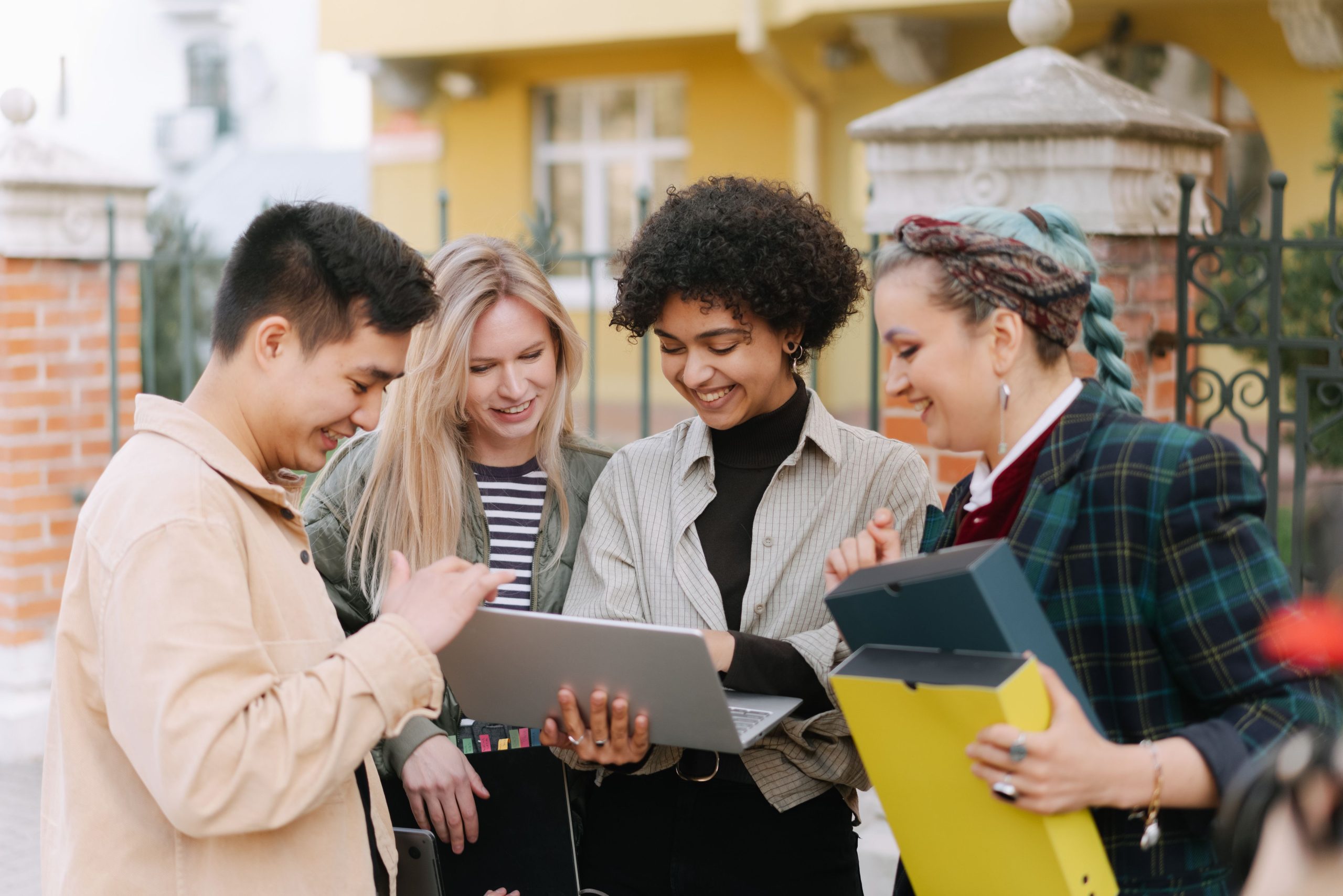 Groupe de jeunes adultes souriant et collaborant en extérieur