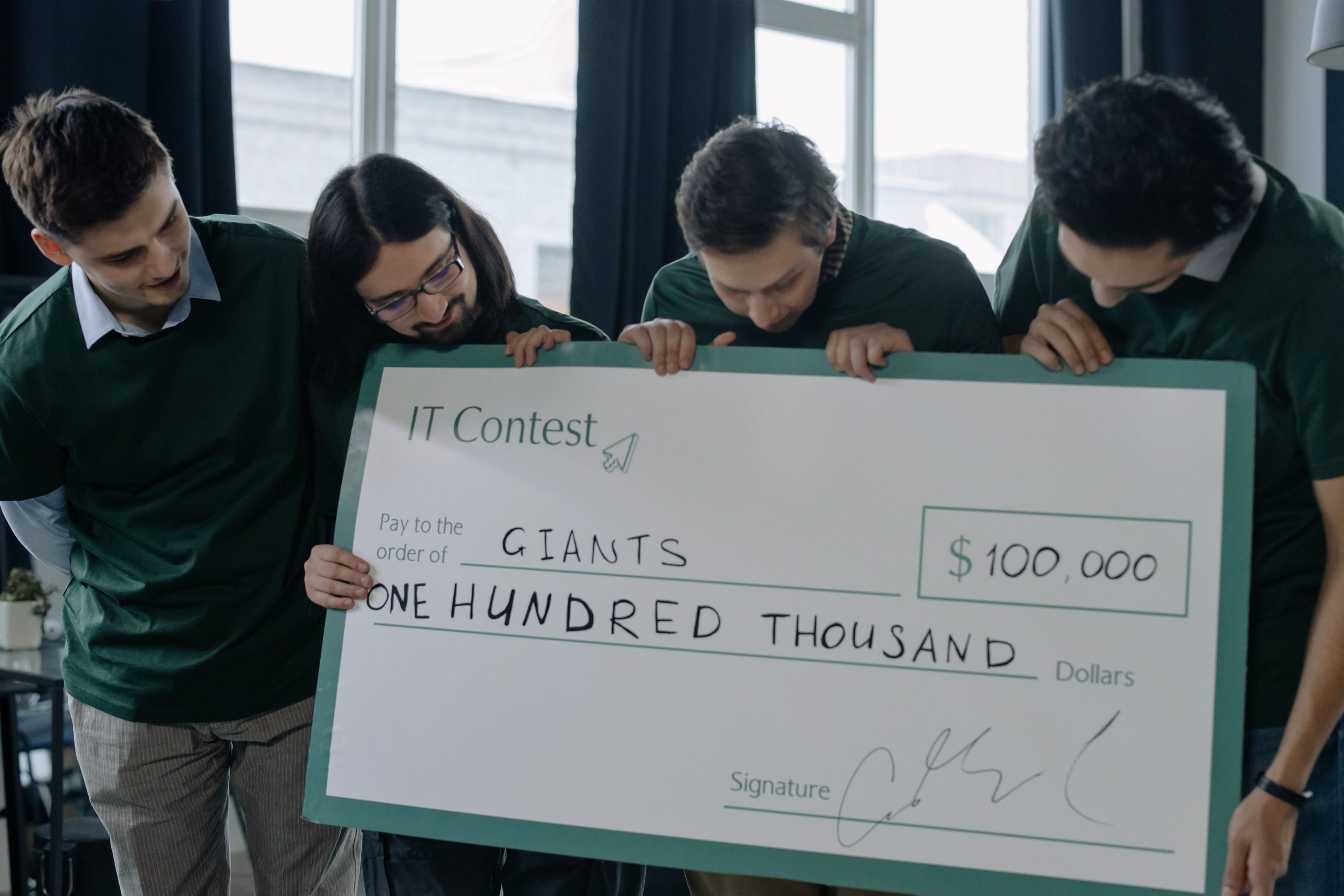 Équipe startup excitée avec chèque de cent mille dollars