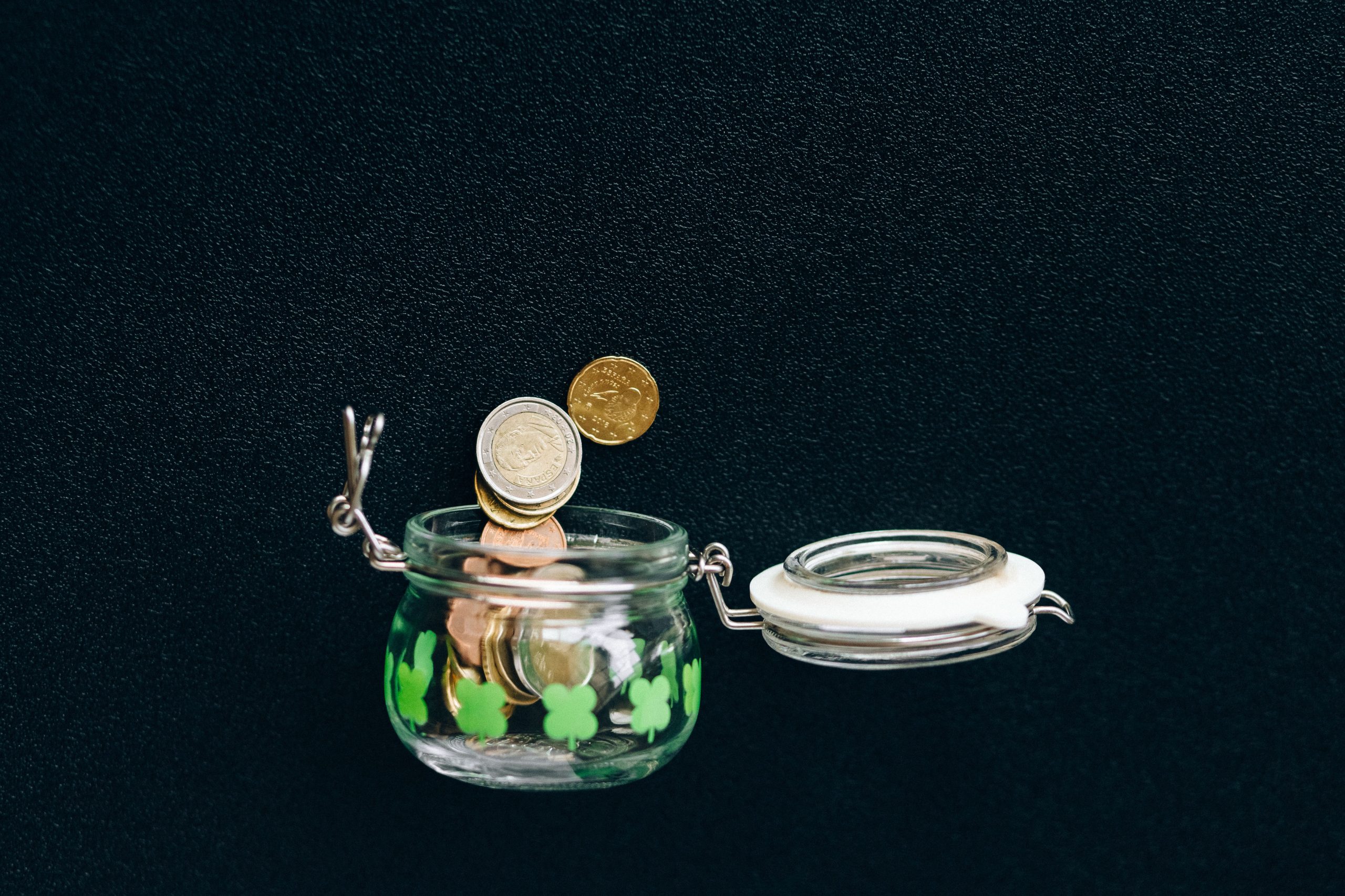 Pièces de monnaie tombant dans un pot d'épargne