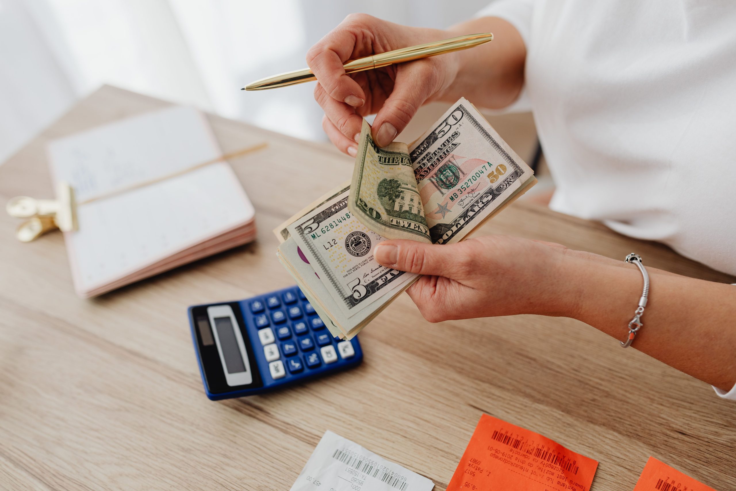 Femme comptant de l'argent avec une calculatrice